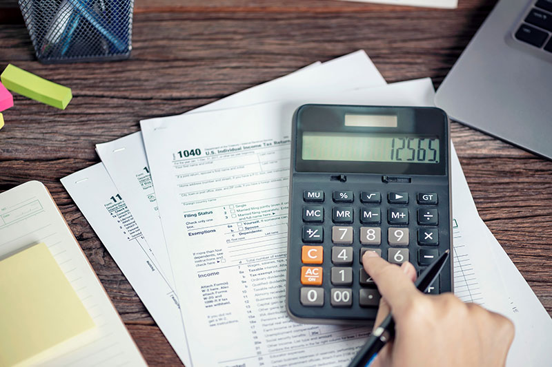 IRS audit attorney: Hand on calculator with tax forms in SC/NC