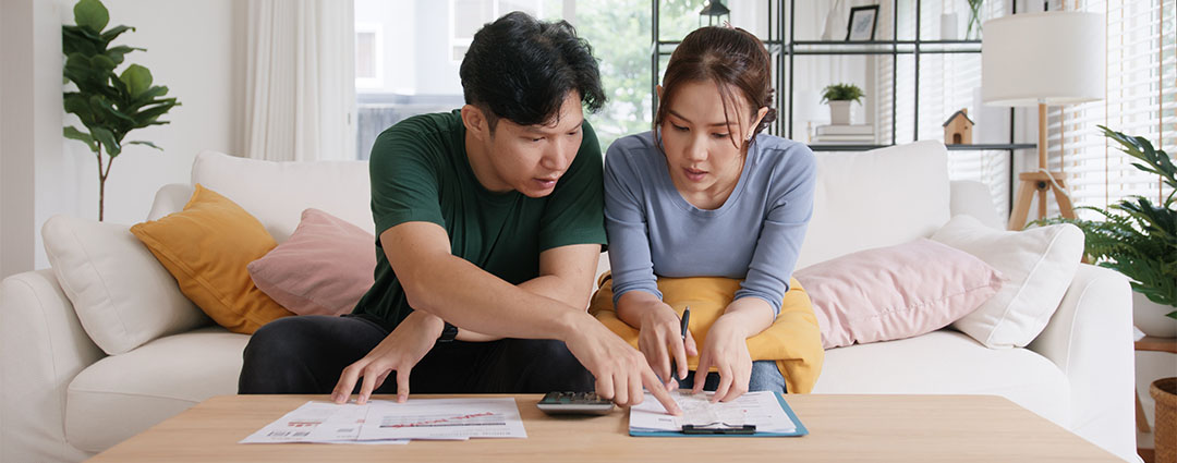 Couple reviews documents, discussing tax debt when only one spouse owes. Get financial clarity now.